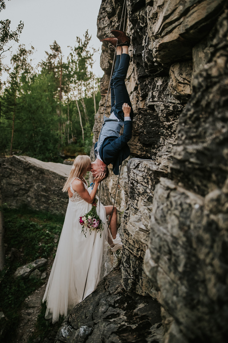 Adventurous climbing couple climbing a mountain in Alta Norway in their wedding attire