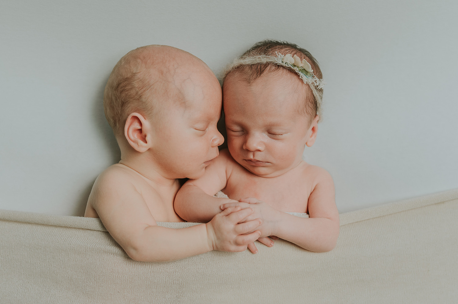 Søte nyfødte tvillinger - baby gutt og baby jente sover søtt på en hvit bakgrunn i fotostudio i Alta
