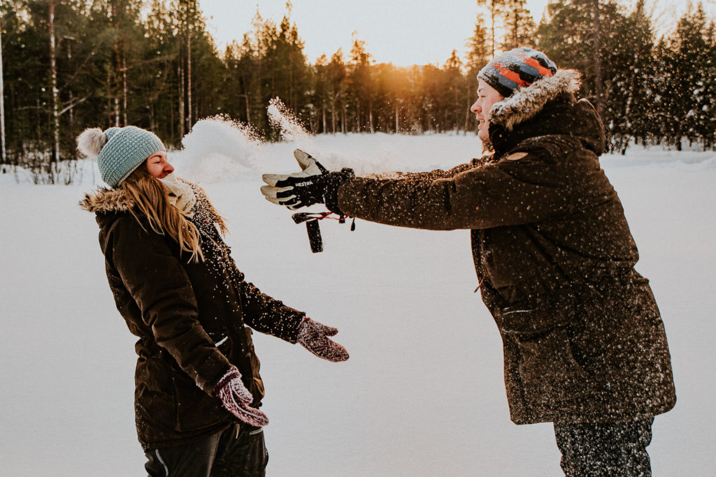 Bridal couple throwing snow at each other forlovelsesfotografering