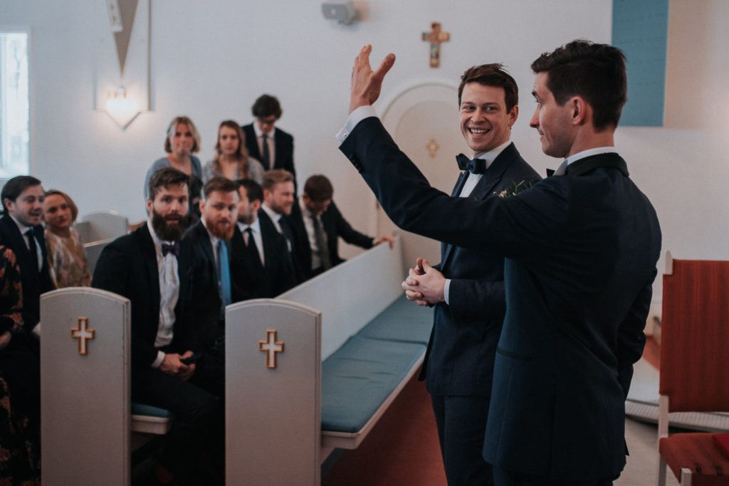 A groom waving to the guests