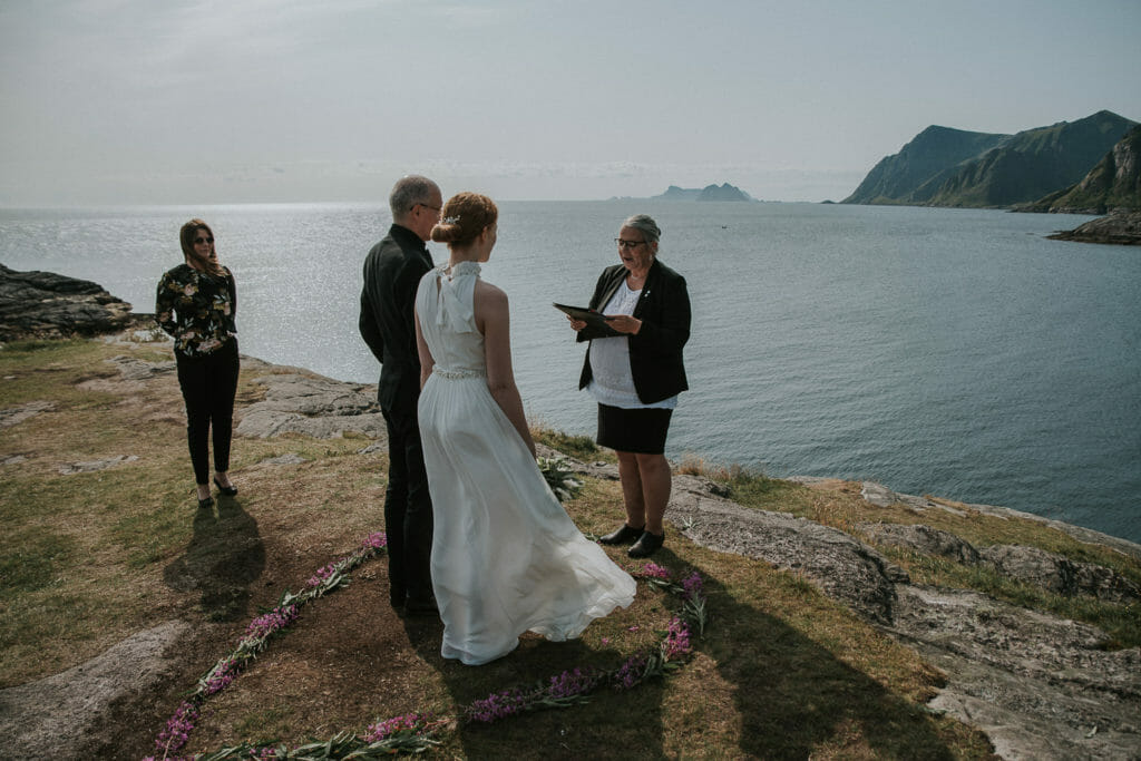 Beautiful bride and groom reading their vows in outstanding landscapes of Lofoten islands in Norway - destination wedding in Northern Norway