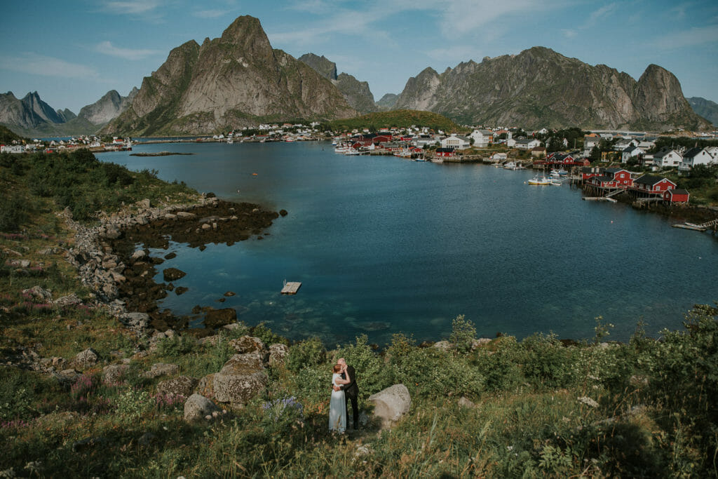 Bride and groom in stunning landscapes of Reine  Sakrisøy Lofoten Norway on the day of their destination wedding in Norway