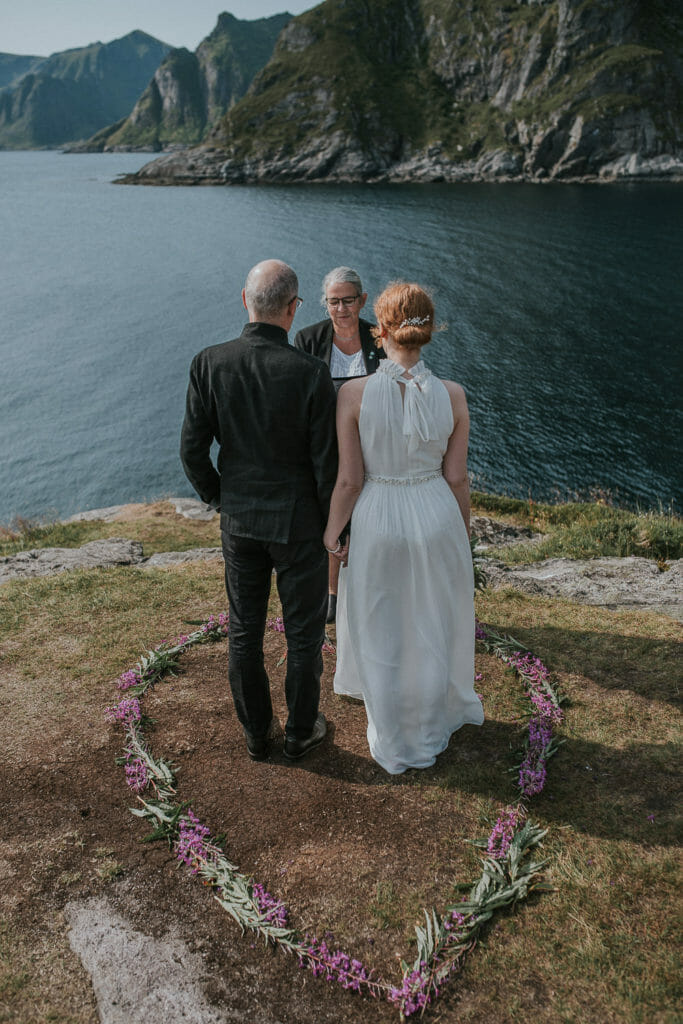 Beautiful bride and groom reading their vows in outstanding landscapes of Lofoten islands in Norway - destination wedding in Northern Norway