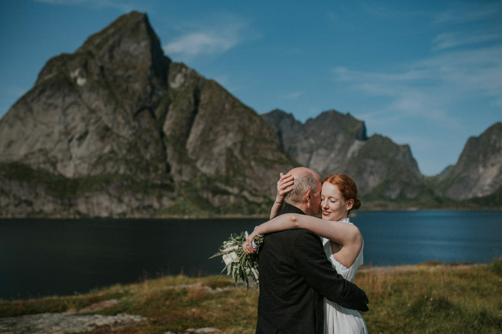 Happy bride and groom hug each other after they gor married in Reine Lofoten Norway