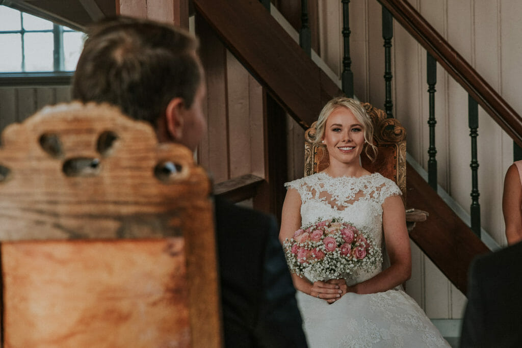 Senja wedding photographer captured stunning bride smiling to her groom during wedding ceremony in Lenvik church in Finnsnes, Troms