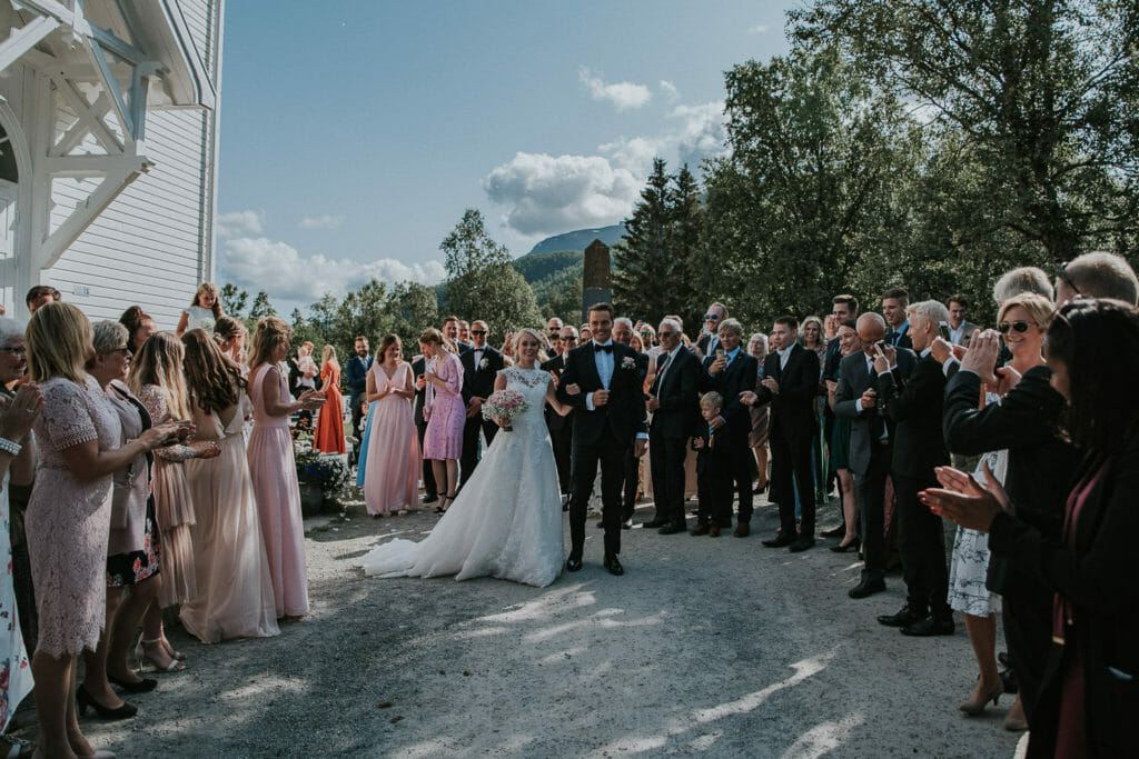 Wedding guests cheering bride and groom who just got married in Senja and walk out of the church in Lenvik