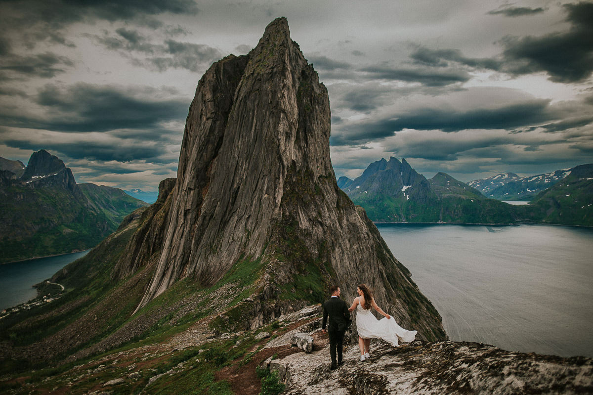 Bride and groom hiking in the mountains among stunning scenery on the day of their adventure elopement in Senja Norway