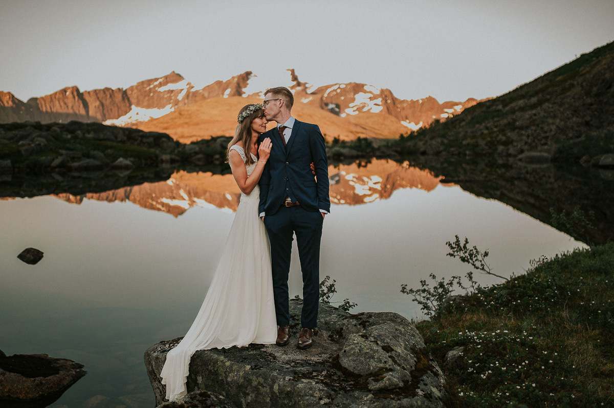 Goegeous bridal couple kissing in front of a beautiful landscape in Tromsø Norway