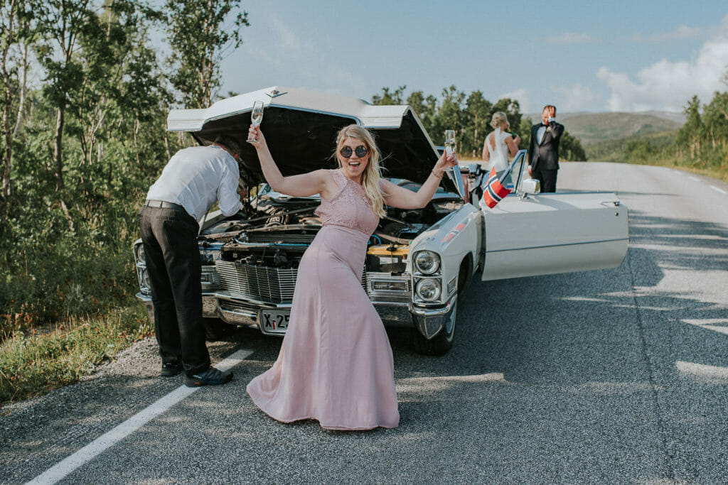 Bridesmaid is joking around while the driver fixes broken bridal car