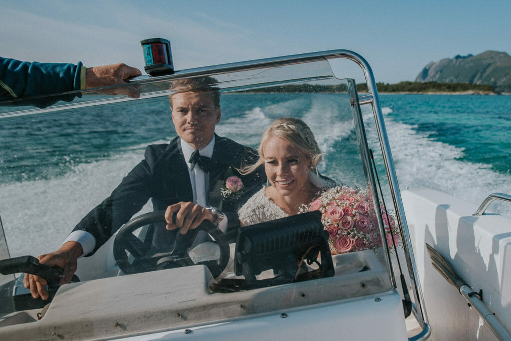 Bride and groom taking a boat trip to a beautiful island outside of Senja in Troms Norway