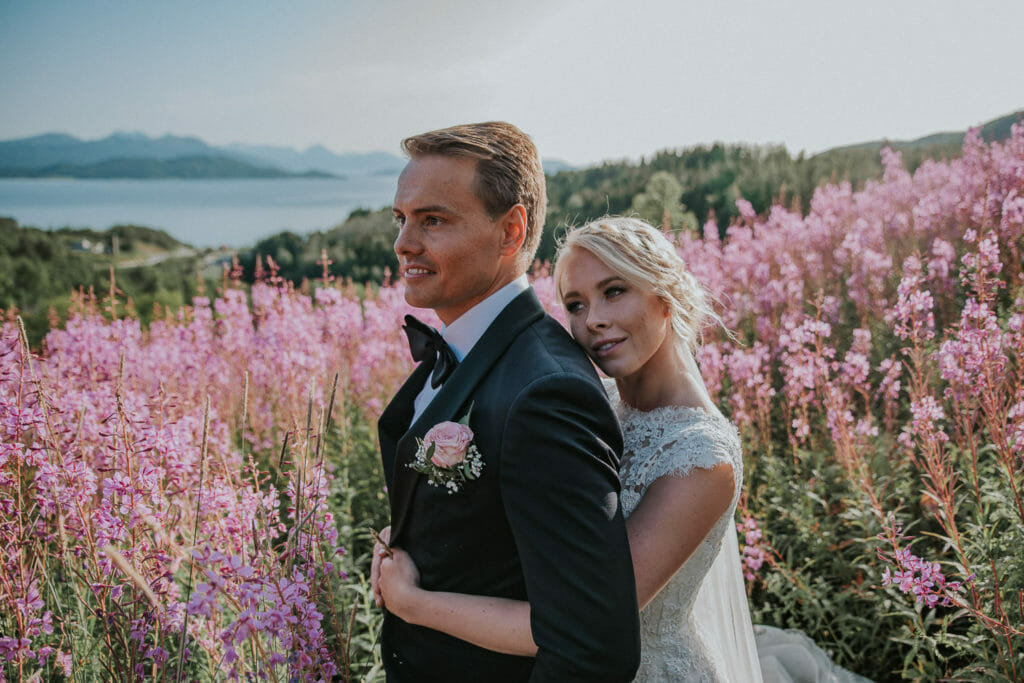 Bride and groom enjoying the moment in a flower field right before the wedding party begins 