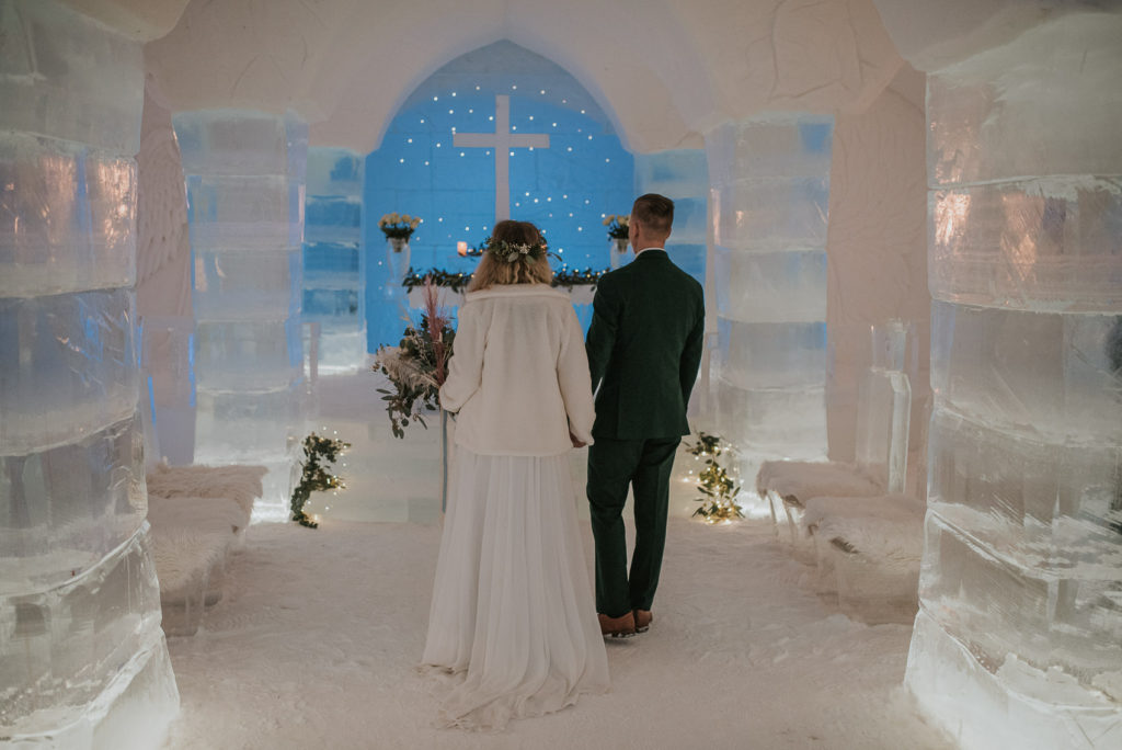 Bride and groom enetering ice chapel in igloo hotel Sorrisniva in Alta Norway