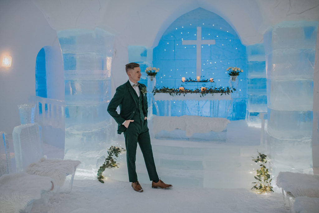 Handsome groom in the ice chapel in Sorrisniva ice hotel waiting for his bride