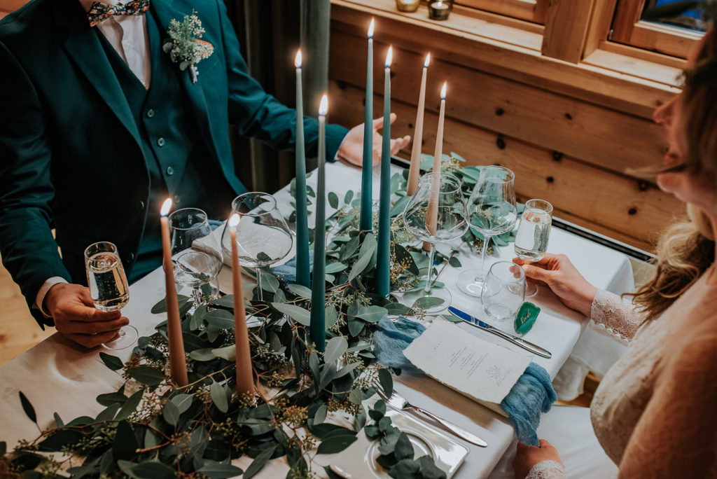 Stunning wedding table decorations with tall candles and green leafs