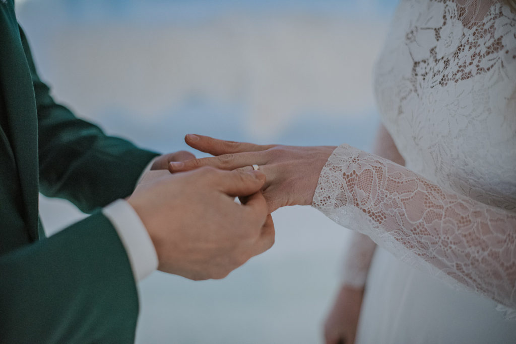 Bride and groom exchanging rings in the ice chapel of Sorrisniva igloo hotel in Alta Norway