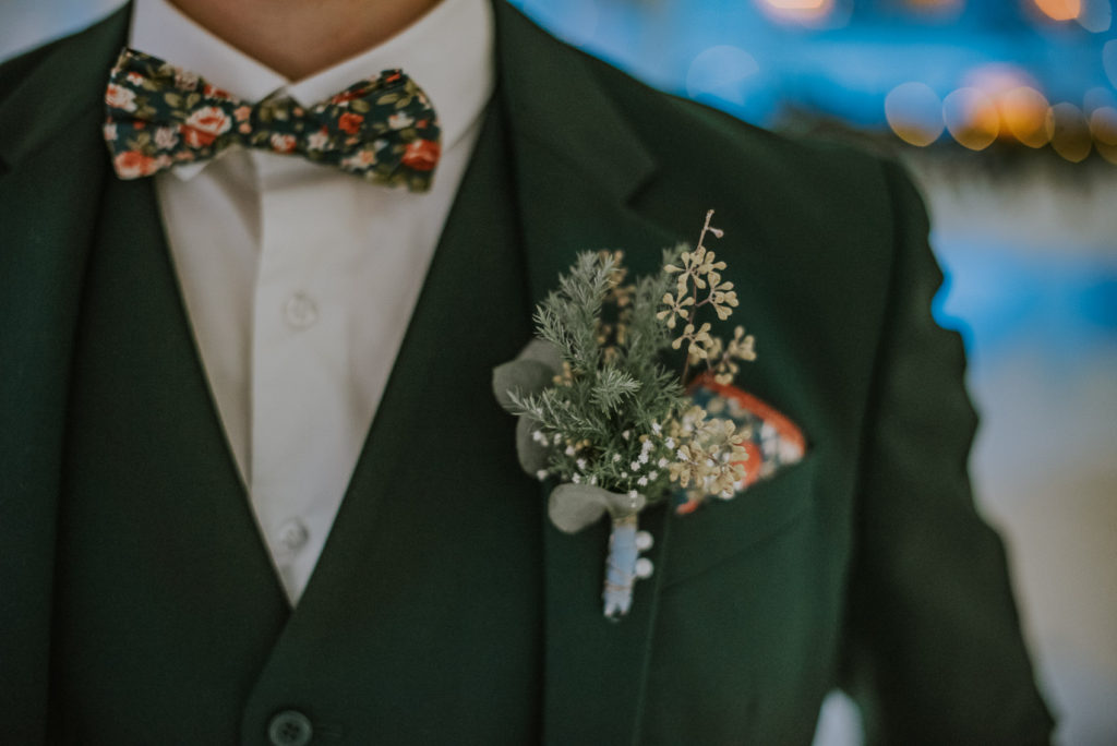 Stylish buttoniere on a green suit for a winter wedding in Norway