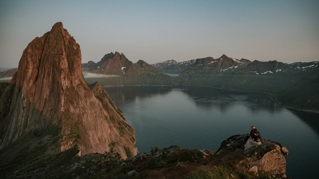 Planning guide for an adventure elopement in Norway - bride and groom enjoying a stunning view from a mountain top