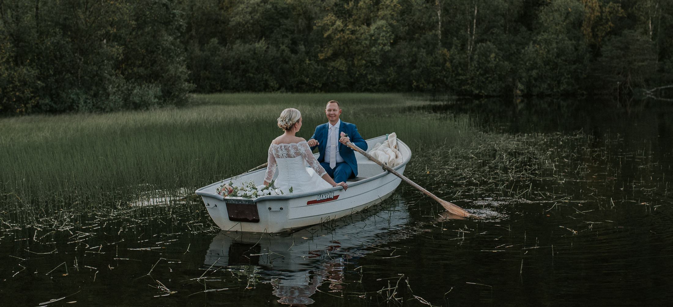lovely bridal couple rowing a boat on a lake in Alta Finnmark Troms