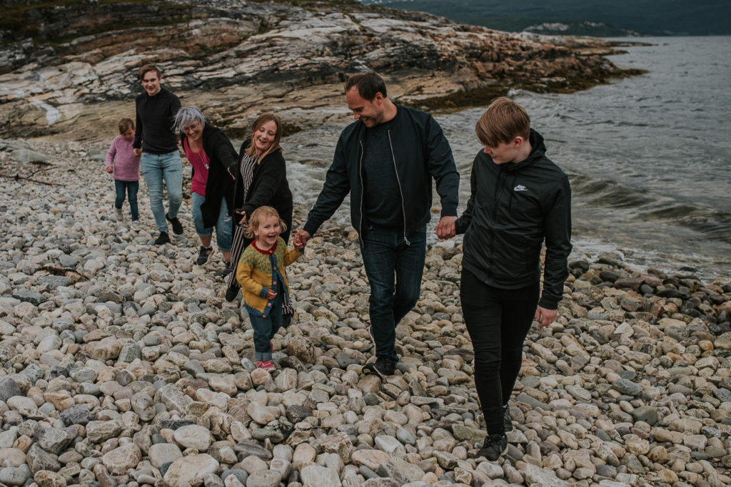 Familie med fem barn leker ved havet i Alta, Troms og Finnmark