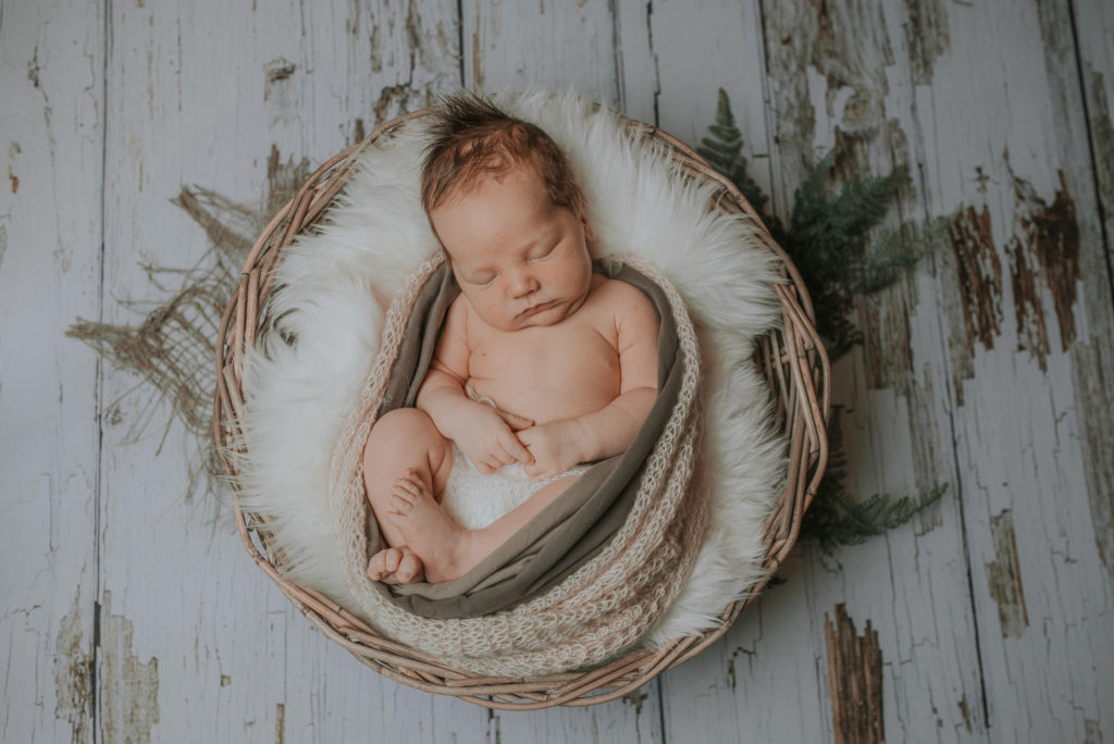 Skjønn baby gutt sover godt i kurven på nyfødtfotografering i Alta hos TS Foto Design