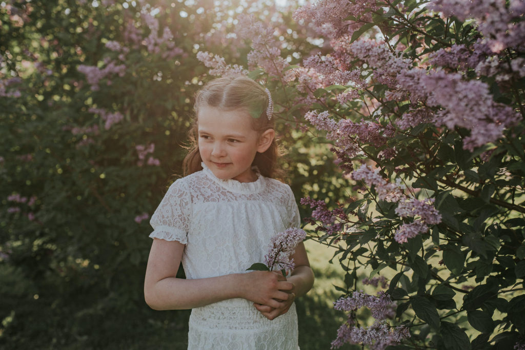 Portrett av en nydelig jente ved syrin-busk 