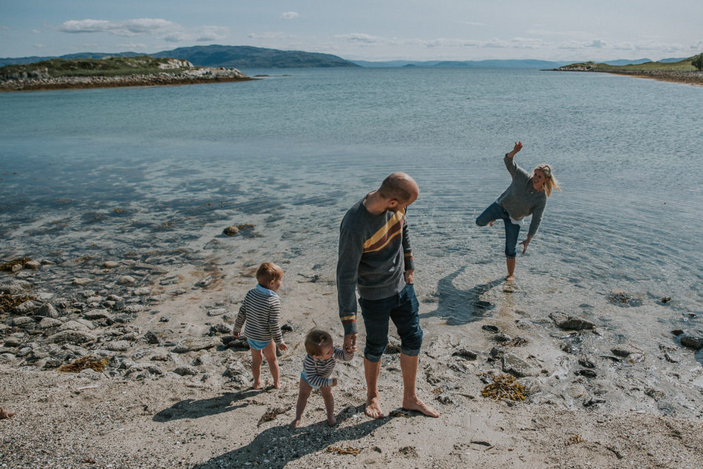En familie leker i vannet på en strand i Finnmark
