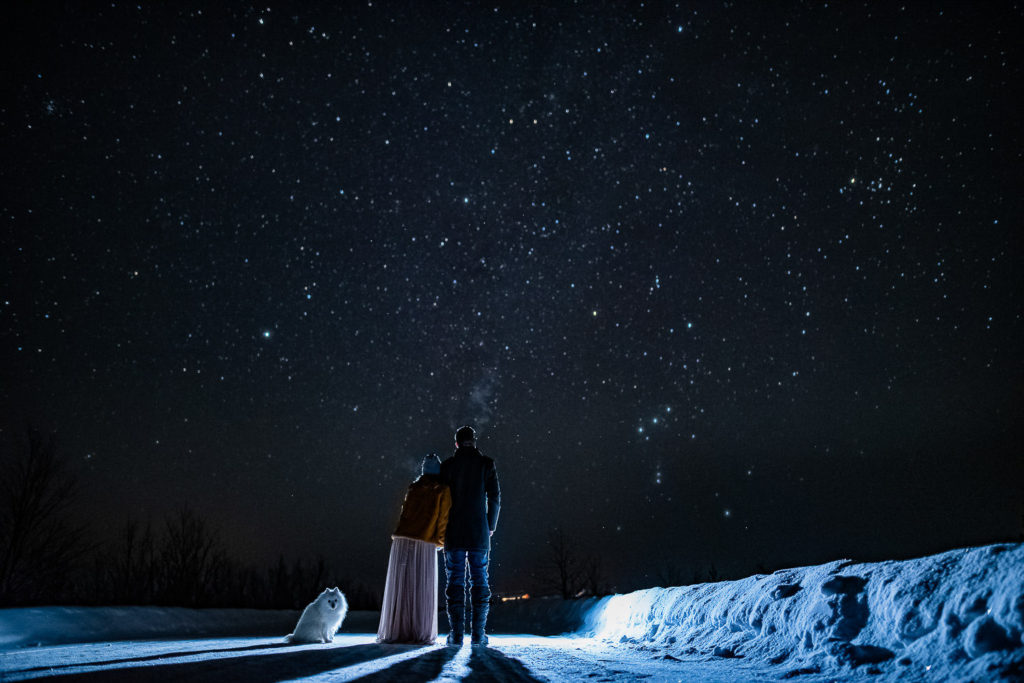 Bride and groom gazing at milky way in the sky in Northern Norway