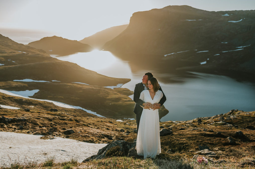 Midnight sun elopement in Norway in the mountains - beautiful couple enjoying the viewa