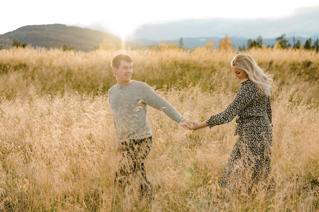 Fall sunset engagement photo session in Norway - beautiful couple is walking in golden fields in Alta