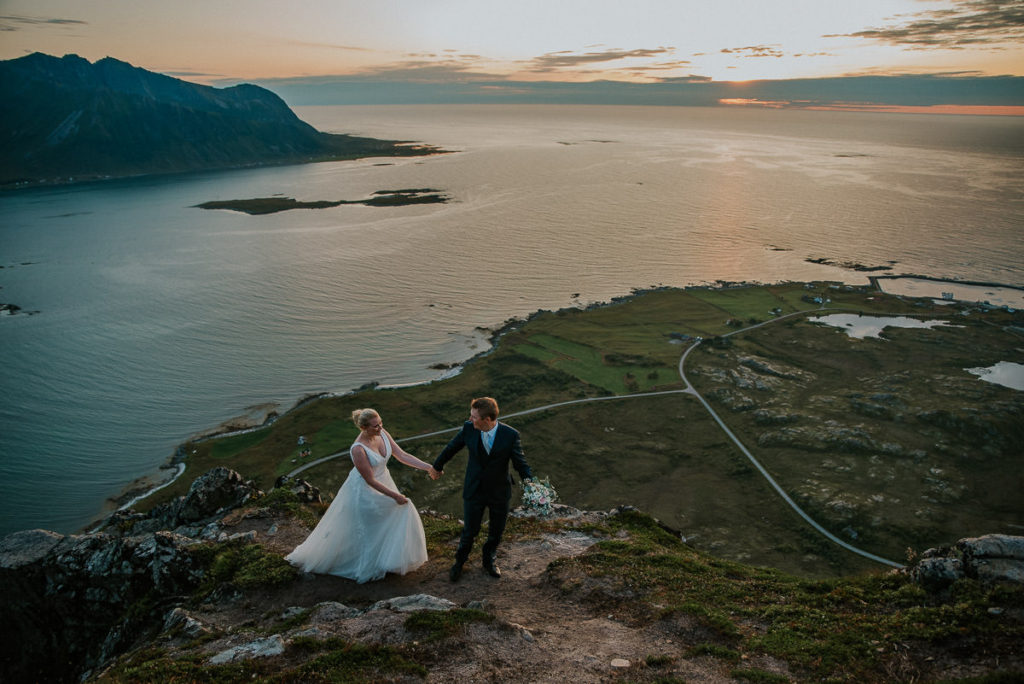 Bride and groom walking in the mountains during beautiful sunset