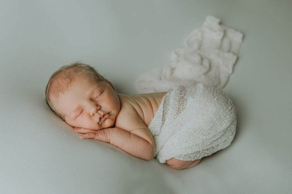 Nyfødtfotograf i Alta tok et nydelig bilde av en baby på hvit bakgrunn