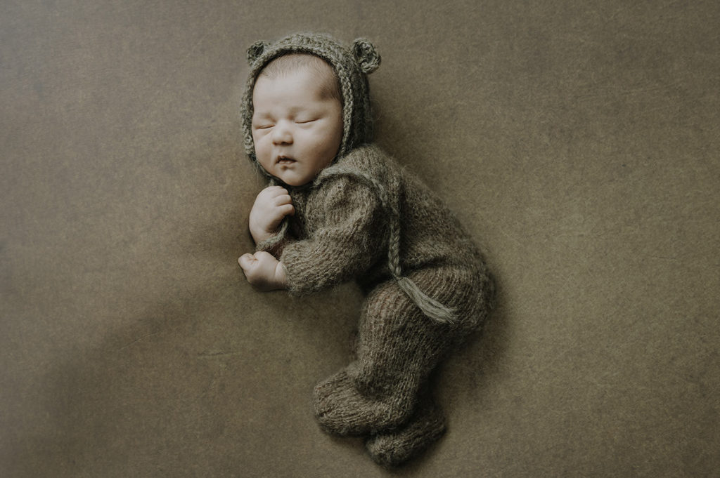 Nyfødtfotografering med bamselue og bamse-outfit