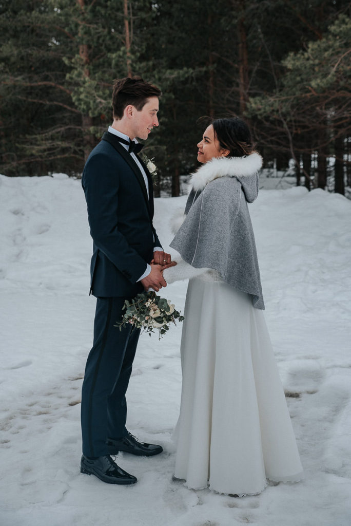 Bride and groom kissing in a winter forest on the day of their elopement in Alta, Norway