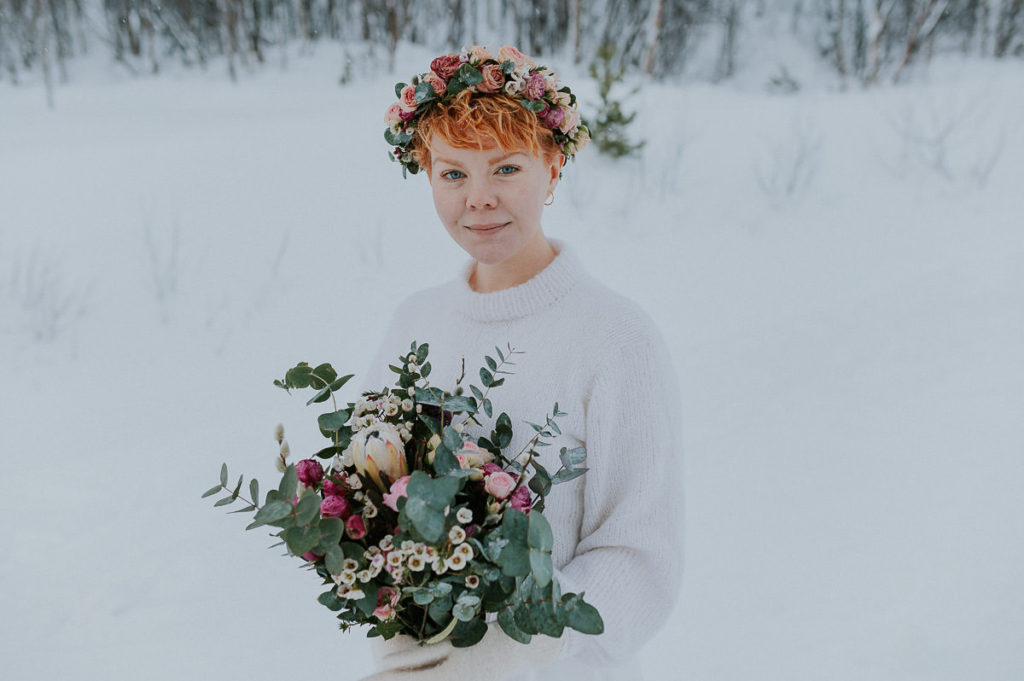 Winter bride in Northern Norway with a beautiful bridal bouquet and flower crown in pink and blush colors