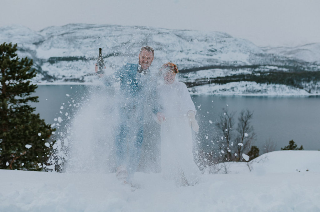 Bride and groom playing with the snow on the day of their elopement in Alta