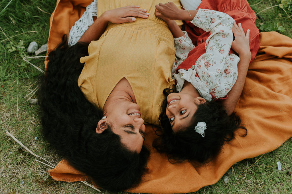 Mor og datter ligger på en gresbakke under mamma og meg fotografering i Alta hos fotograf TS Foto Design