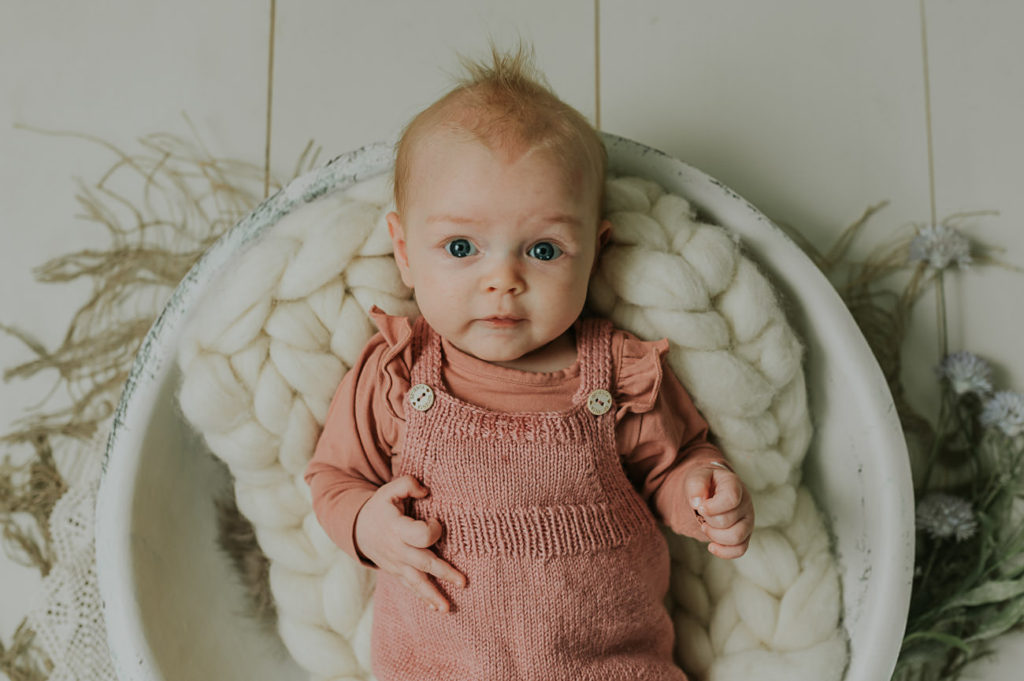 Søt 3 måneder gammel jente på babyfotografering i fotostudio i Alta i lyse farger