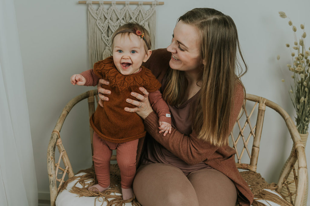 Ett år i bilder - babyfotografering fra måned til måned - bilde av mor og 10 måneder gammel baby i armene i lyse studio omgivelser. 