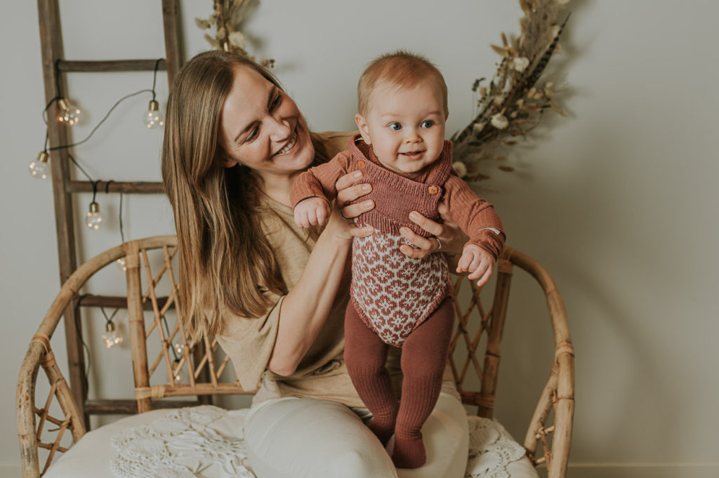 Ett år i bilder - babyfotografering fra måned til måned - bilde av mor og 7 måneder gammel baby i armene i lyse studio omgivelser