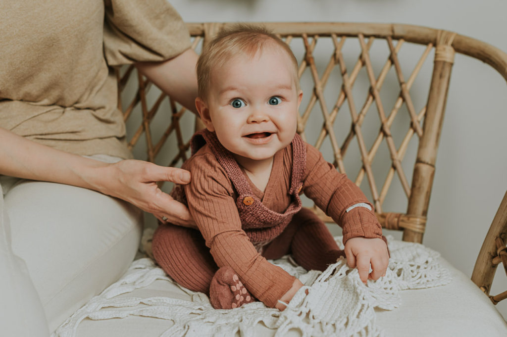 Milepælfotografering med 7 måneder gammel baby - babyen sitter i en rottingstol og smiler