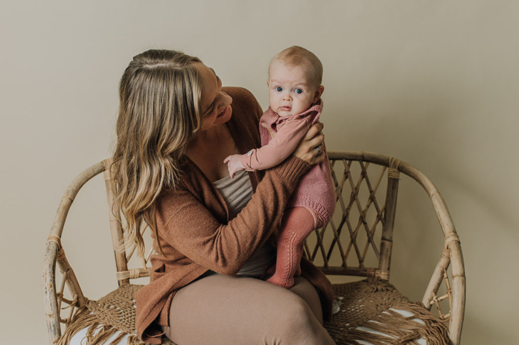 Ett år i bilder - babyfotografering fra måned til måned - bilde av mor og 4 måneder gammel baby i armene i lyse studio omgivelser