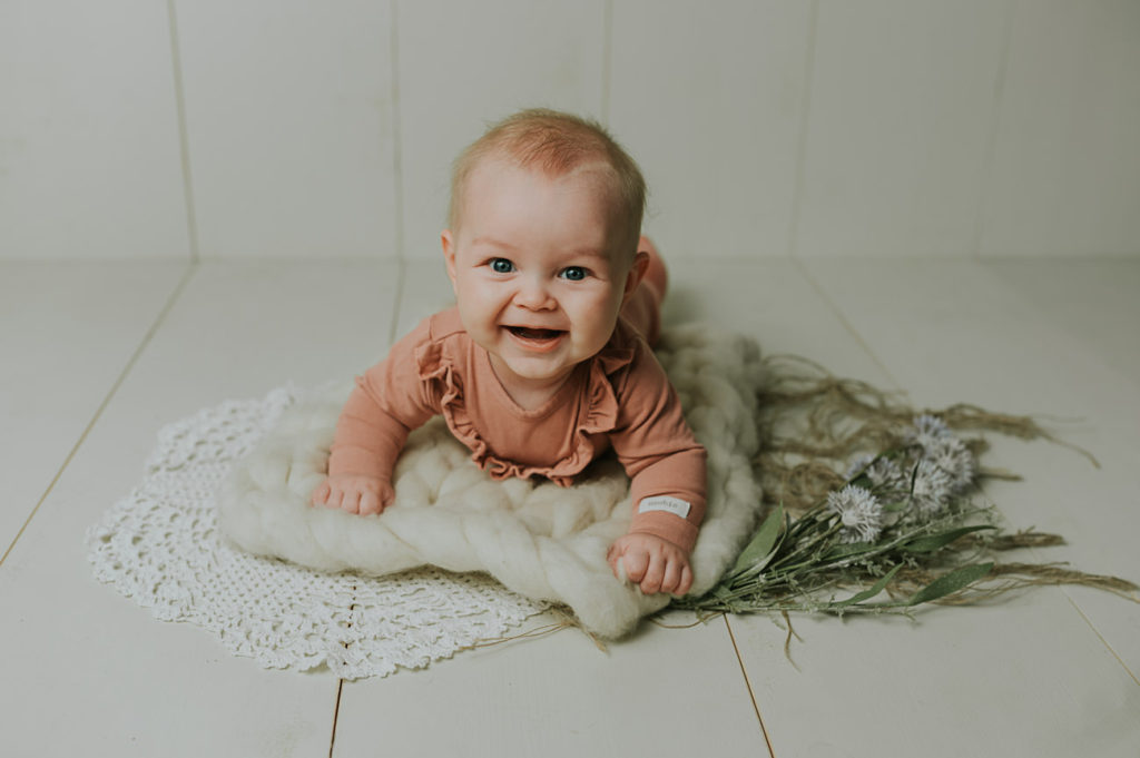 Søt baby jente på 5 måneder ligger på magen på milepælfotografering i Alta i fotostudio TS Foto Design