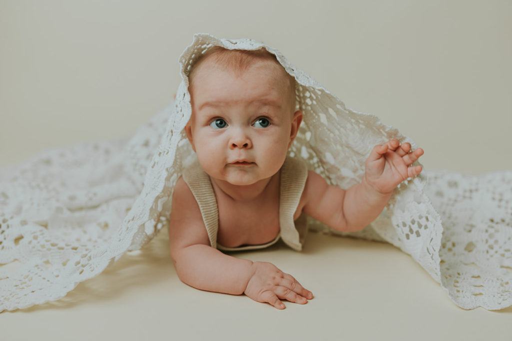 Søt baby jente på 5 måneder ligger på magen på milepælfotografering i Alta i fotostudio TS Foto Design