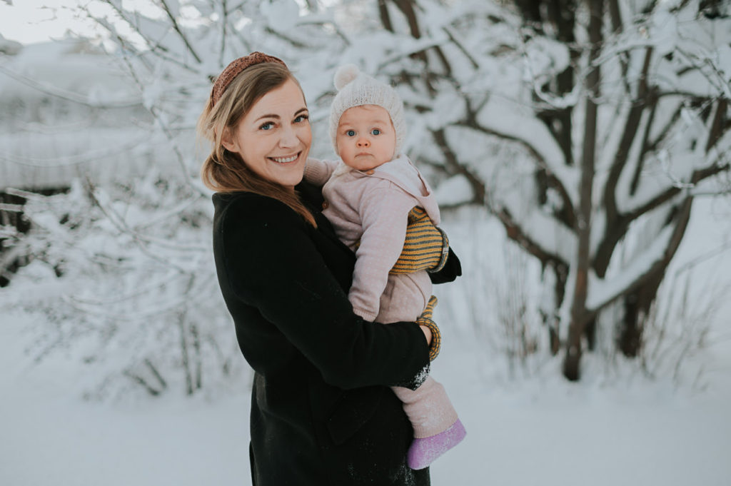 Portrett av mor og baby datter utendørs i Alta i nydelige vinter omgivelser med snø og soloppgang 