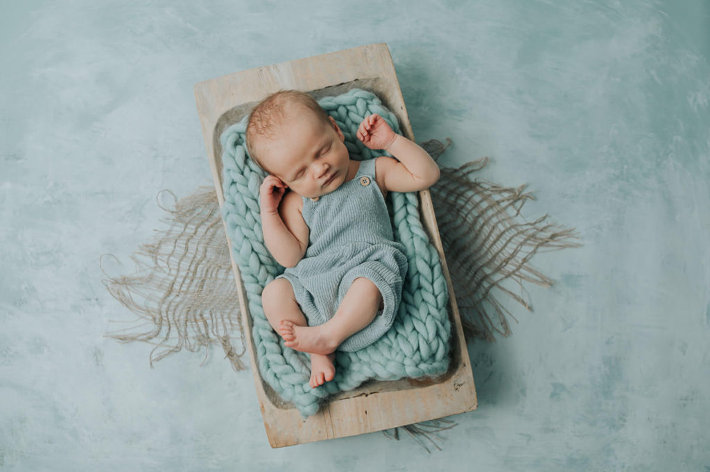 Cute baby in a trench on a blue mintgreen backdrop - sea, beach and maritime newborn photo session theme