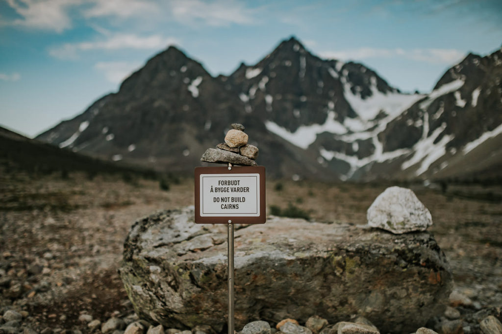 "Do not build cairns" sign in front of a rocky trail in Lyngen Alps in Norway 