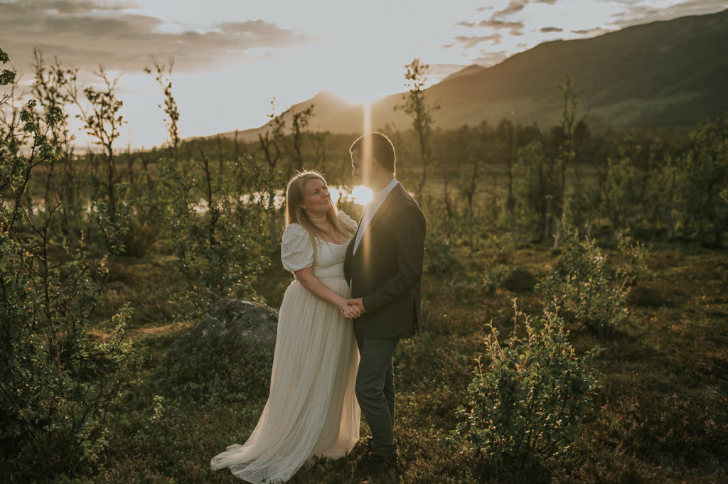 Bride and groom in the rays of midnight sun in Northern Norway