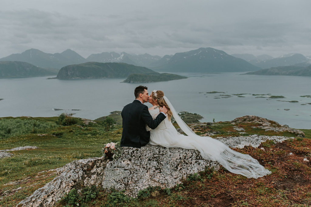 Sommarøy wedding in Tromsø - bride and groom kissing on top of Hillesøy