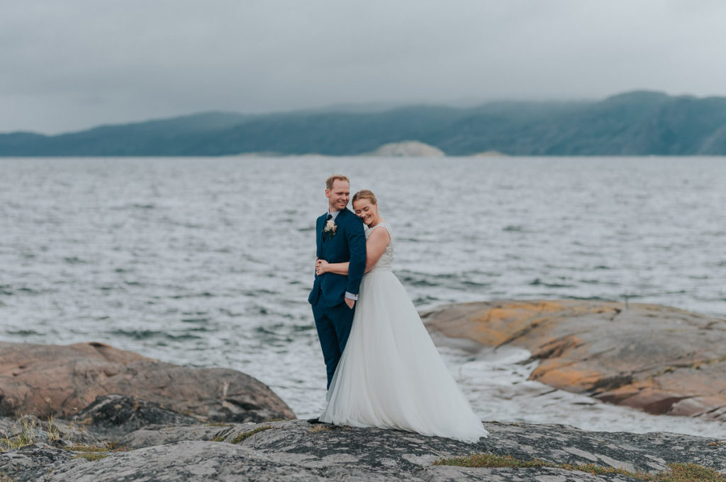 Nydelig brudepar på svabergene ved havet i Alta med flott utsikt til Altafjord