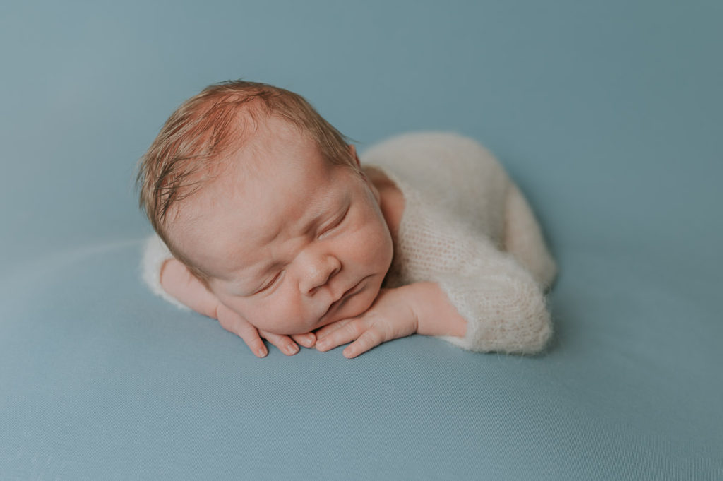 Nyfødt gutt  i hvit strikket drakt sover på nyfødtfotografering i fotostudio i Alta fotografert av nyfødtfotograf TS Foto Design